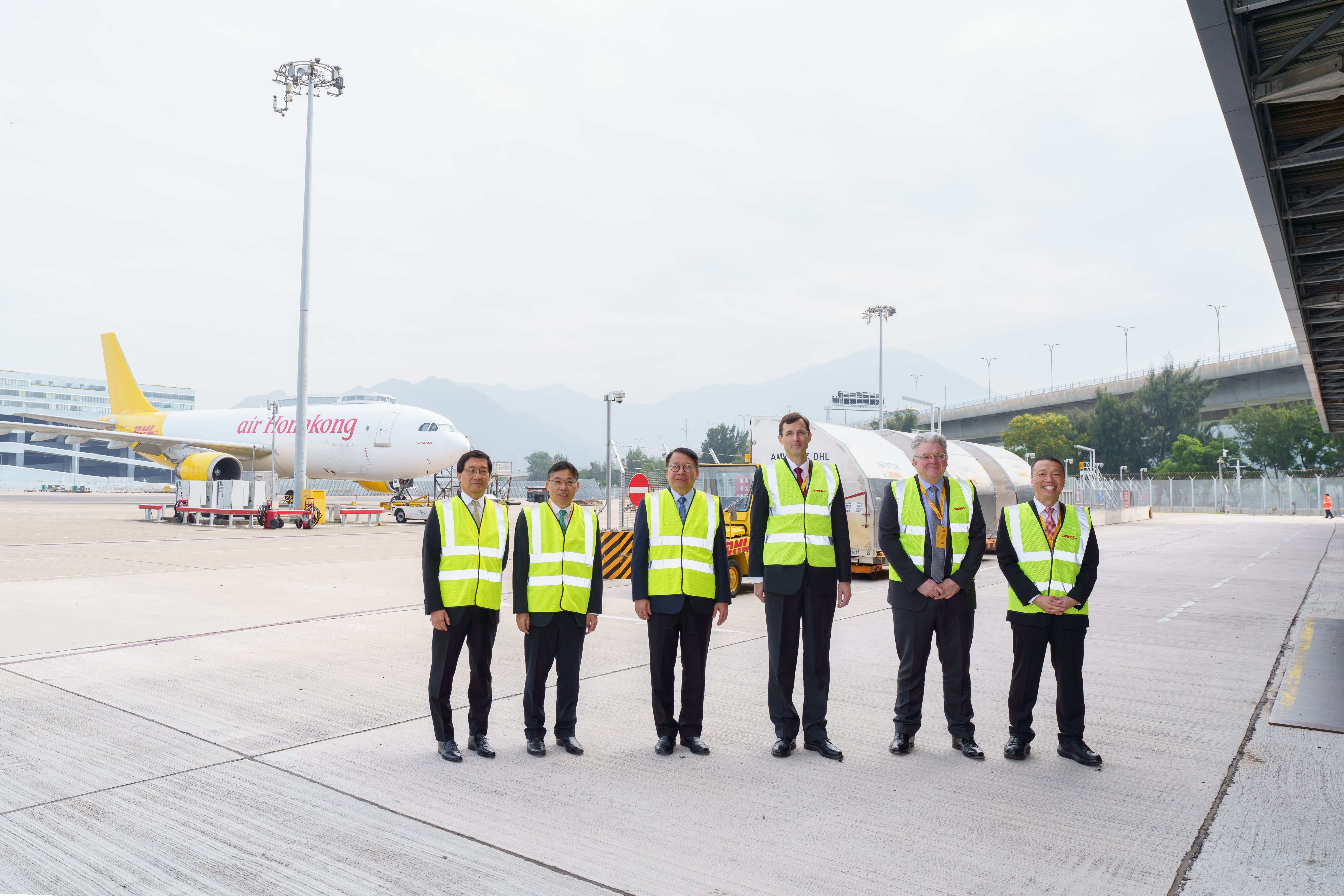 Officiating guests include: KK Chan, Chief Secretary for Administration of the Government of the Hong Kong Special Administrative (third from left);Lam Sai-hung, Secretary for Transport and Logistics of the Government of the Hong Kong Special Administrative (second from left);Fred Lam, CEO of Airport Authority Hong Kong (first from left);Tobias Meyer, CEO of DHL Group (third from right);John Pearson, CEO of DHL Express (second from right); andKen Lee, CEO of DHL Express Asia Pacific (first from right),