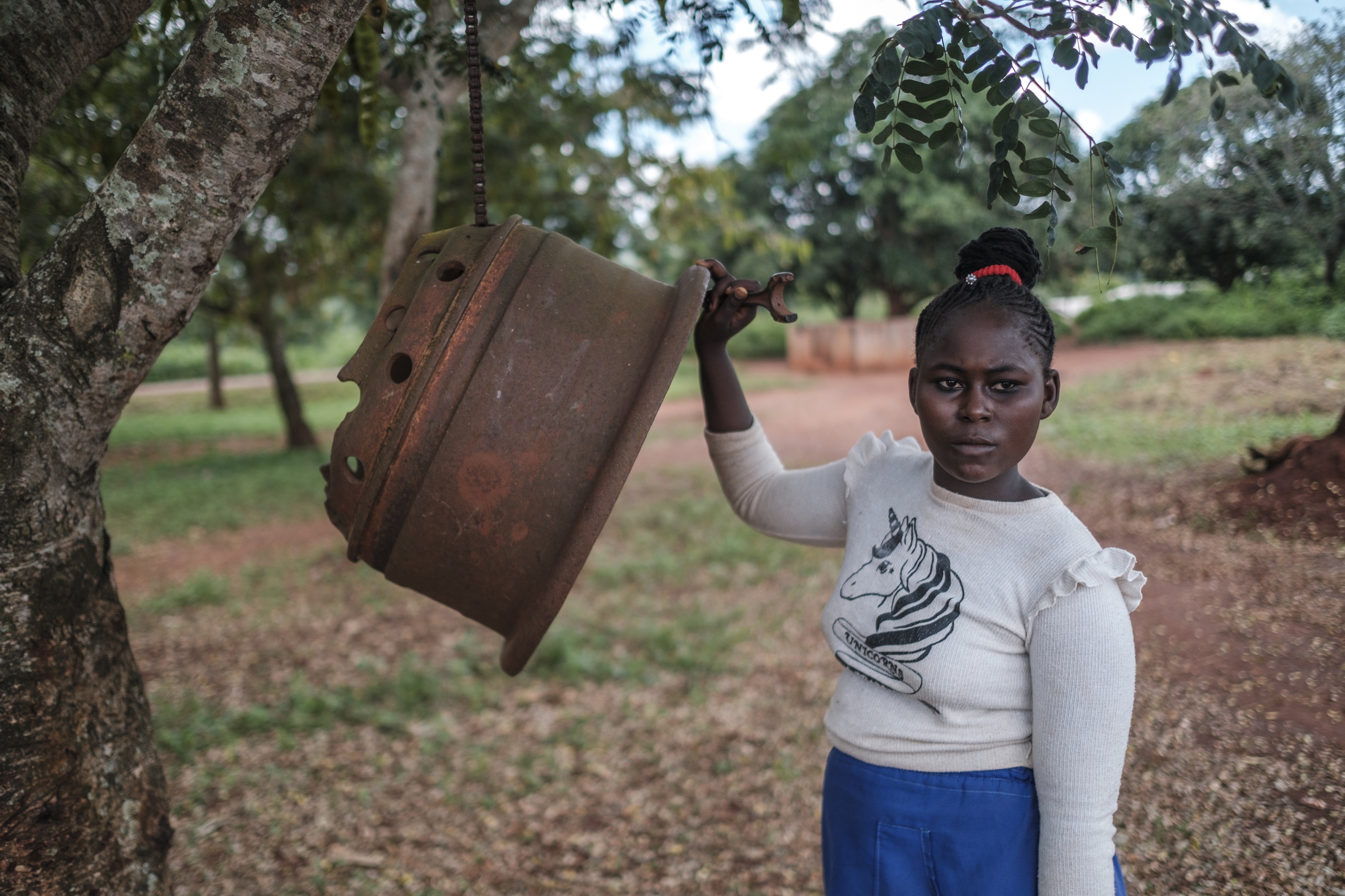 Student Naomi Bakeré rings a metal bell at break time at the Boyali 2 school, in the village of Boyali, Central African Republic. (Eduardo Soteras/AP Images for Global Partnership for Education)